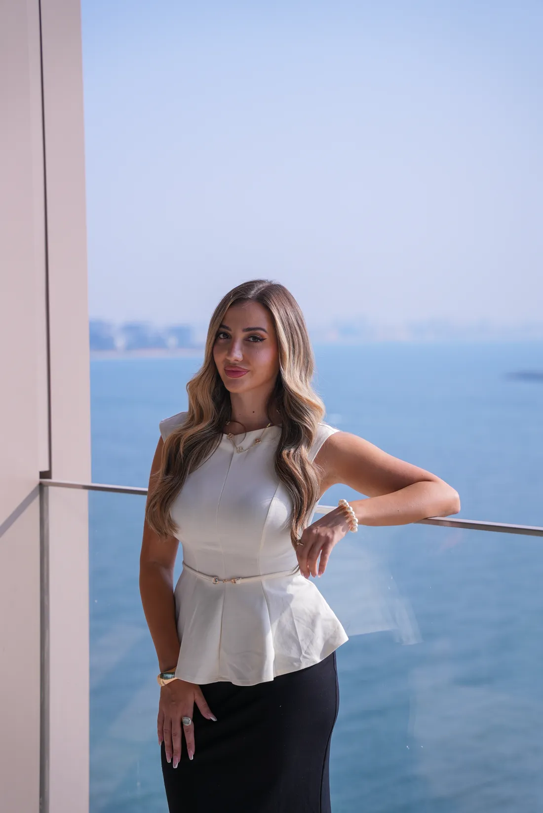 Andrea Jiga on a balcony overlooking the sea in Dubai